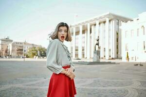 fofa Loiras menina com vermelho lábios ao ar livre dentro a cidade posando andar foto