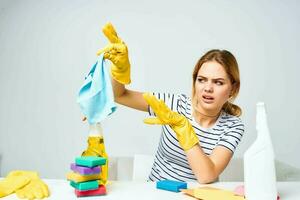 mulher segurando uma trapo limpeza detergente suprimentos tarefas domésticas interior foto