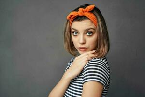 bonita elegante mulher com laranja arco de cabelo vermelho saia posando foto