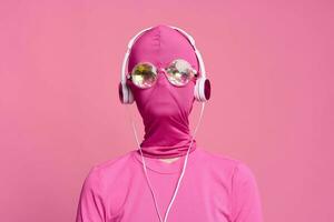 mulher arte batidas conceptual retrato em brilhante Rosa cera vestindo brilhante néon copos, Rosa mascarar e fones de ouvido foto