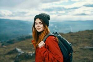 alegre mulher caminhante caminhando dentro a montanhas ativo período de férias viagem foto
