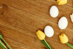 branco frango ovos amarelo tulipas decoração Primavera feriado de madeira fundo foto