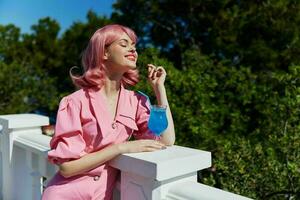 Deleitado jovem menina com Rosa cabelo verão coquetel refrescante beber inalterado foto