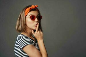 alegre mulher vestindo oculos de sol laranja curativo em cabeça isolado fundo foto