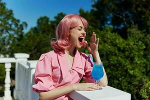 alegre mulher com Rosa cabelo verão coquetel refrescante beber feliz fêmea relaxante foto