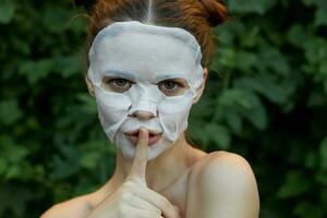 retrato do uma menina dedo perto lábios solicitação para silêncio branco mascarar cosmetologia foto