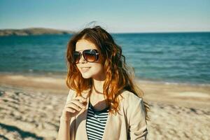 mulher dentro oculos de sol em a de praia mar panorama verão foto
