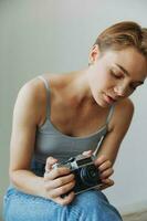 mulher fotógrafo tiroteio dentro estúdio em velho filme Câmera às casa em sofá retrato, branco fundo, livre cópia de espaço, freelance fotógrafo foto