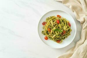 macarrão fettuccine espaguete com molho pesto e tomate foto