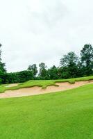 verde com bunkers de areia no campo de golfe foto