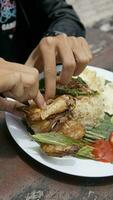 grelhado frango com arroz e legumes em a de madeira mesa dentro a restaurante foto