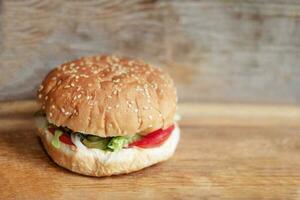 grande carne hamburguer com pães com sésamo sementes em de madeira fundo, fechar acima foto