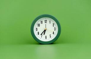 relógio precioso Tempo alarme relógio em verde fundo conceito do Tempo trabalhando com Tempo foto