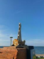estátua do uma navio Como a ícone em uma de praia às a gorjeta do Java foto