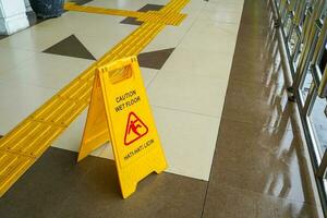 Atenção instruções, Cuidado placa molhado chão em chão foto
