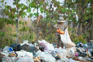 crianças pobres recolhem e separam resíduos para venda, conceitos de pobreza e meio ambiente. foto