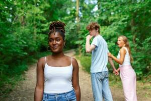 desleal homem caminhando com dele namorada e olhando espantado às outro sedutor menina foto