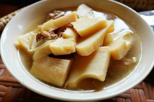 caseiro bambu tiro fervido com carne de porco ossos sopa dentro branco tigela é tradição tailandês Comida. foto