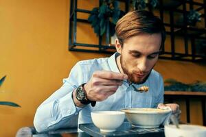 homem comendo sopa almoço lanche dentro uma restaurante foto