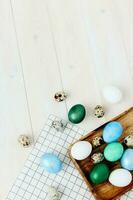 Páscoa ovos do diferente cores mentira em uma de madeira mesa cópia de espaço e uma xadrez guardanapo foto