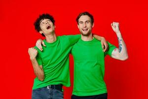 dois alegre amigos abraço verde Camisetas emoções comunicação vermelho fundo foto