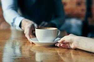 feliz barman servindo uma copo do café para uma paciente dentro uma cafeteria beber tijolo parede interior foto