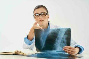 mulher médico sentado às a mesa radiologista diagnóstico profissionais foto