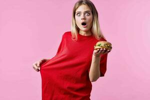 mulher dentro vermelho camiseta velozes Comida lanche Rosa fundo foto