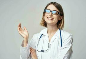 fêmea enfermeira dentro médico vestido gesticulando com mãos em luz fundo cortada Visão foto