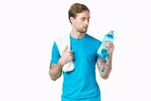 bonito homem com uma garrafa do água dentro dele mãos esporte ginástica tatuagem foto