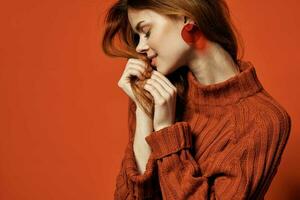 atraente ruivo mulher vermelho suéter brincos joalheria moda foto