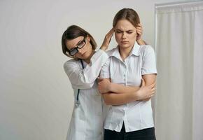 profissional médico mulher dentro óculos toques a cabeça do a paciente em uma luz fundo foto