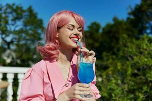 Deleitado jovem menina bebendo uma coquetel em a terraço feliz fêmea relaxante foto