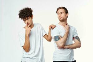 dois homens dentro branco Camisetas estão em pé lado de lado isolado fundo foto