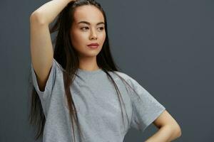 mulher com grandes cabelo dentro uma cinzento camiseta gesticulando com mãos estúdio modelo foto