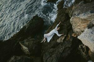 lindo jovem mulher dentro branco Casamento vestir em mar costa molhado cabelo inalterado foto