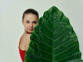 mulher dentro vermelho roupa de banho Palma folha atraente Veja isolado fundo foto