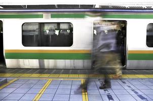 Tóquio, Japão - 13 de novembro de 2014 - movimento de passageiros caminhando na plataforma da estação jr durante a hora do rush em Tóquio, Japão foto