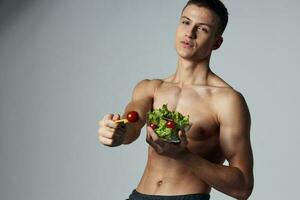 Atlético cara com nu ombros prato do salada saudável Comida vegetariano foto