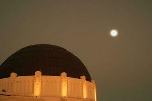 Griffith observatório com uma cheio lua dentro a fundo foto