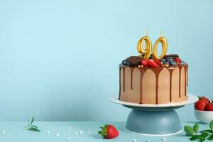 chocolate aniversário bolo com bagas, biscoitos e número noventa dourado velas em azul parede fundo, cópia de espaço foto