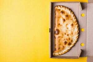 fechadas pizza calzone dentro embalagem caixa em amarelo fundo foto