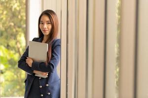 mulher de negócios asiáticos segurando laptop foto