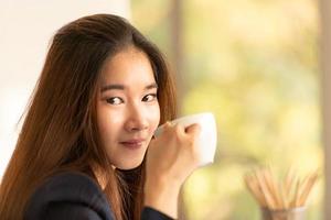 mulher de negócios asiática tomando café em um escritório