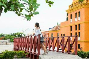 lindo mulher em branco vestir em pé sozinho às a paredes em torno da do a colonial cidade do cartagena de índias foto