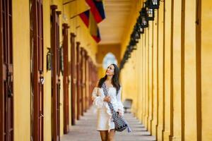 lindo mulher caminhando por aí a murado cidade dentro cartagena de índias foto