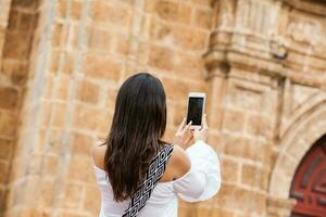 lindo mulher levando As fotos do a san Pedro claver Igreja localizado dentro a murado cidade do cartagena de índias