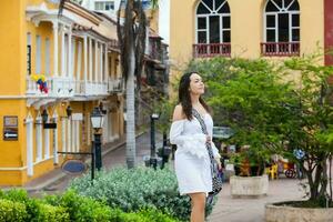 lindo mulher em branco vestir caminhando sozinho às a paredes em torno da do a colonial cidade do cartagena de índias foto