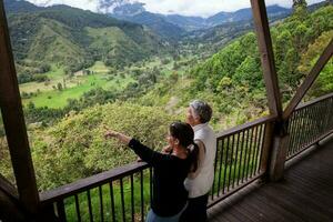 Senior mãe e adulto filha viajando juntos às a lindo Visão ponto sobre a cocora vale às Salento, localizado em a região do quindio dentro Colômbia foto