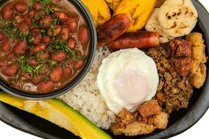 tradicional colombiano prato chamado banda paisa uma prato típica do Medellin este inclui carne, feijões, ovo e bananeira foto